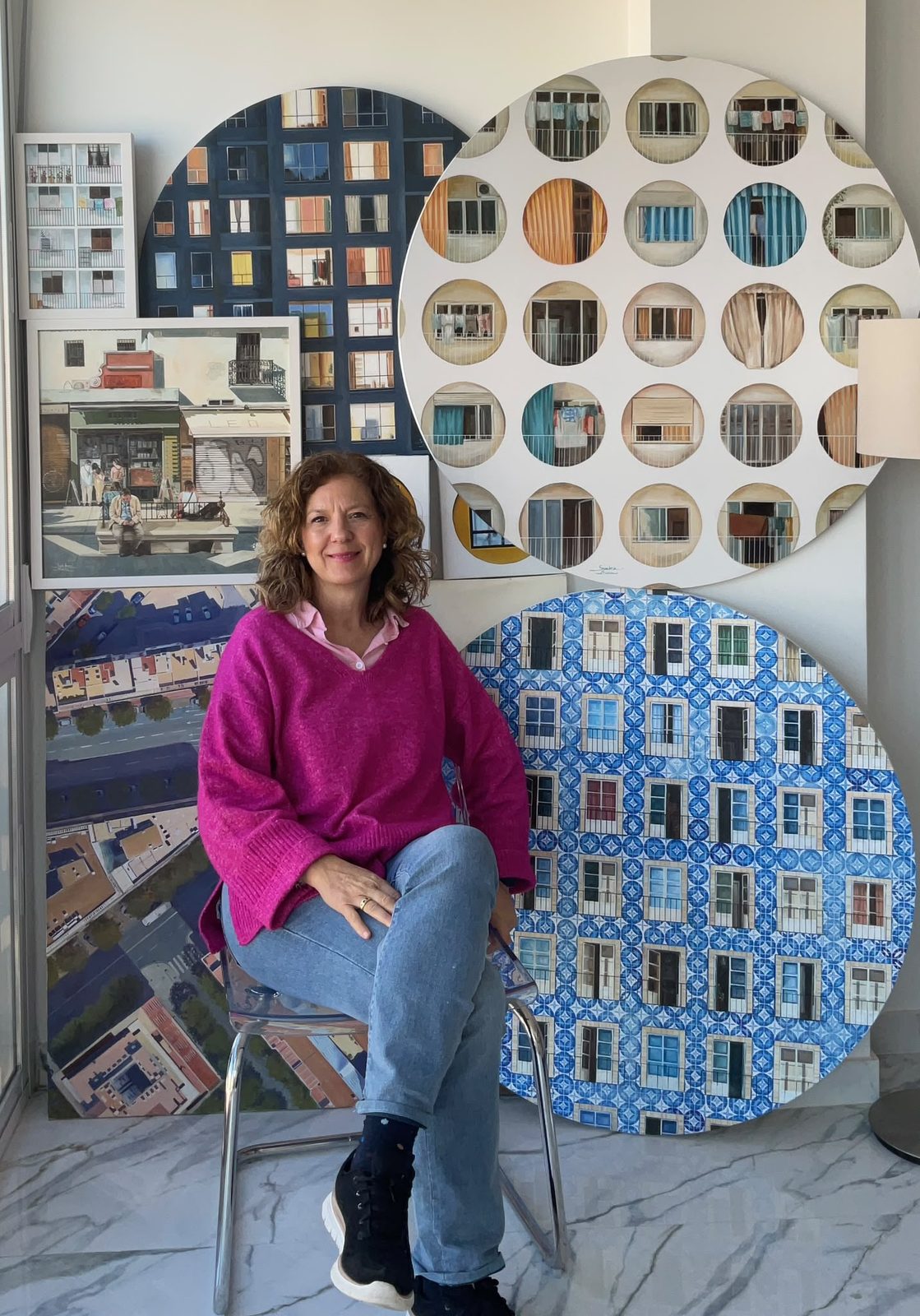 Carmen Sánchez Ruda rodeada de varias de sus obras de fachadas y ventanas