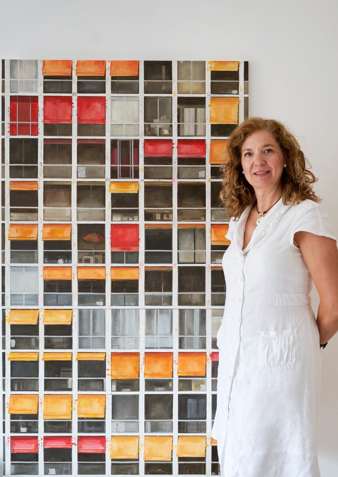 Carmen Sánchez Ruda junto a una de sus obras de fachadas y ventanas en cuadrícula